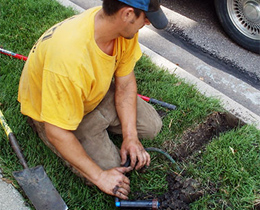 a Bellaire sprinkler repair tech is replacing a broken sprinkler