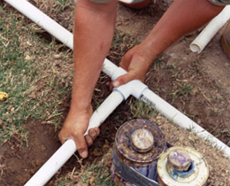 a sprinkler repair pro is doing a pipe re-routing